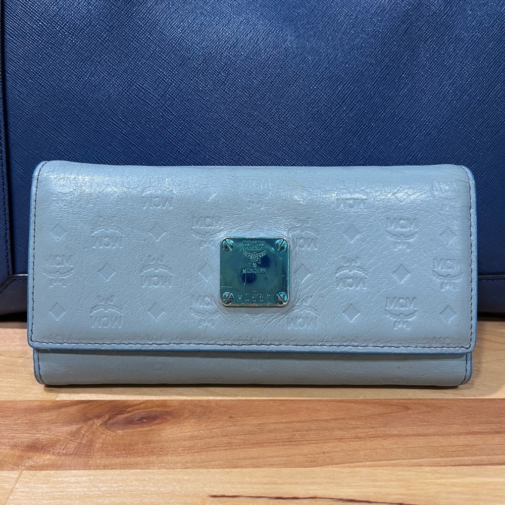 MCM Munchen trifold wallet in new condition except scratches on name plate.